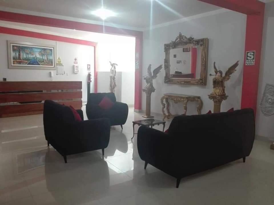 salon z 2 krzesłami, stołem i lustrem w obiekcie Hostal Los Angeles w mieście Tarapoto