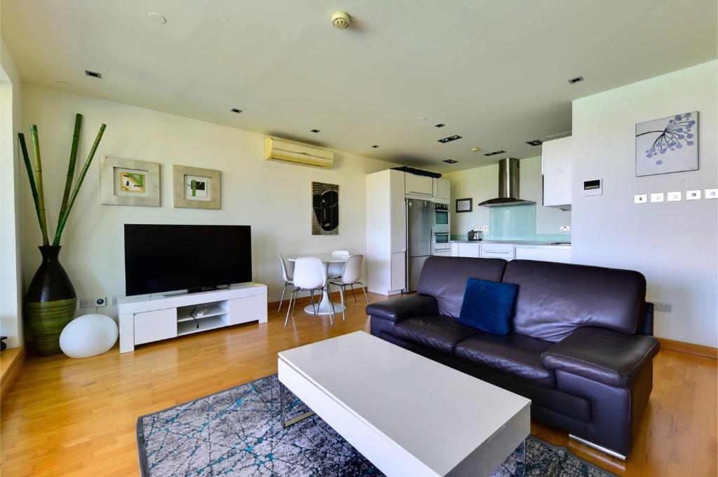 ein Wohnzimmer mit einem Sofa und einem TV in der Unterkunft Ocean Village Royal Gibraltar in Gibraltar