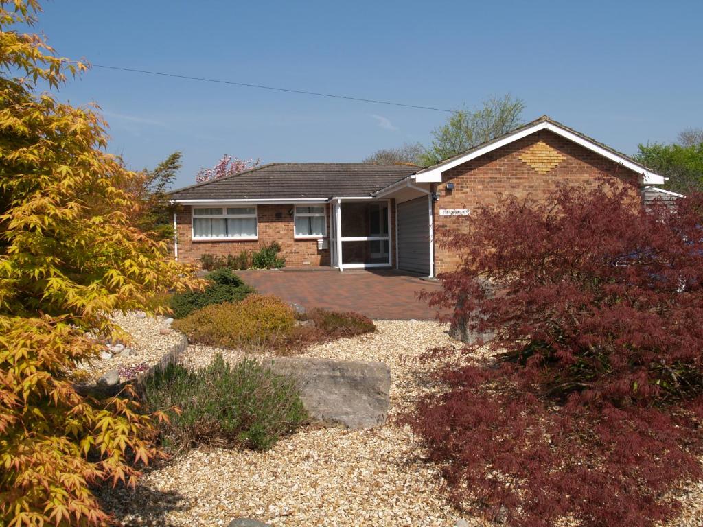 a brick house with a patio in front of it at Tradewind, Easton Lane, Freshwater in Freshwater