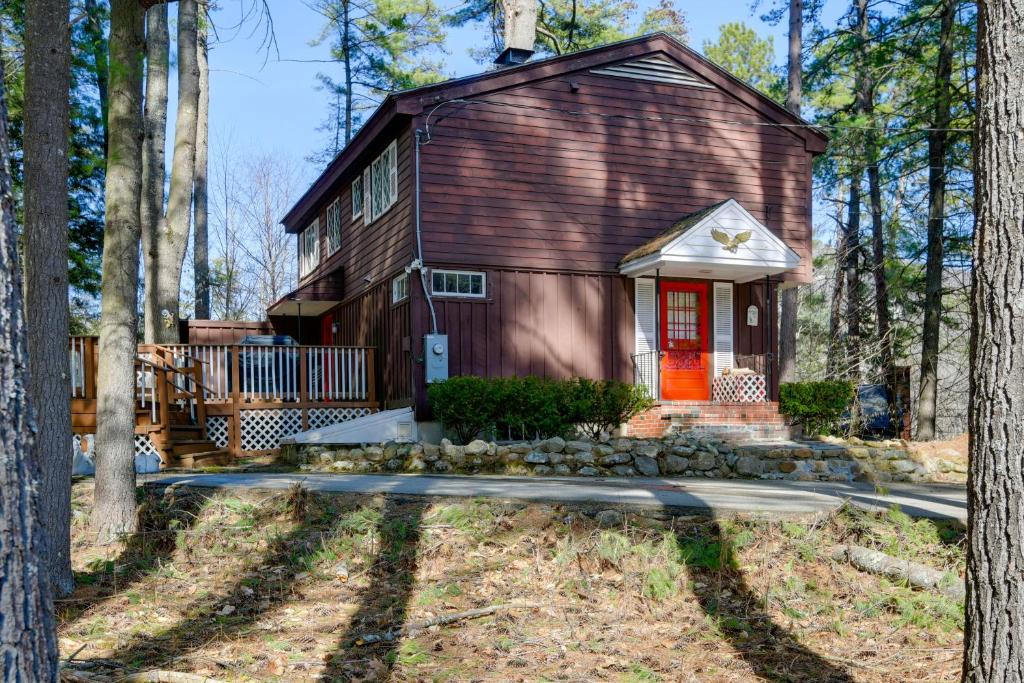 a small house with a red door in the woods at North Conway Home Less Than Walk to Slopes at Cranmore! in North Conway