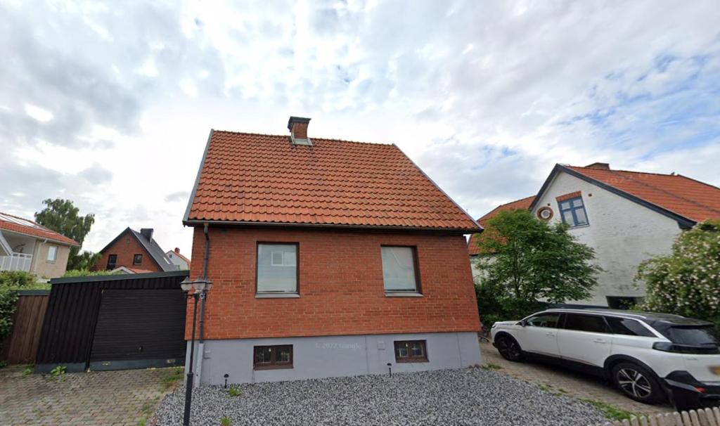 a brick house with a white car parked in a driveway at House in the middle of Malmö in Malmö