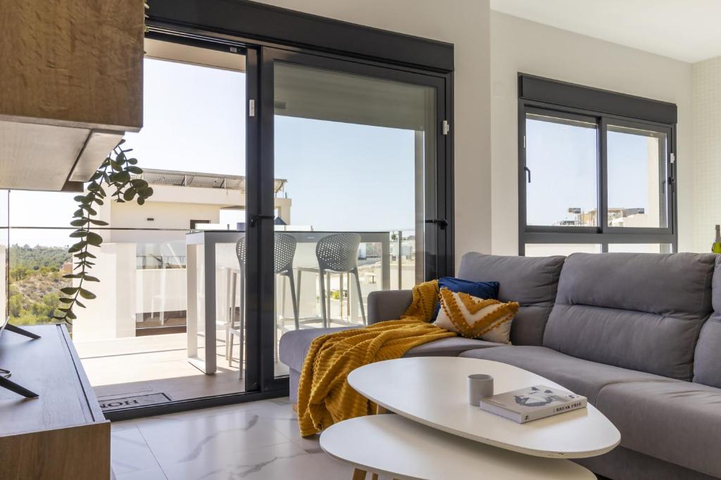 un salon avec un canapé et une table dans l'établissement Top floor Pink Vistagolf - Winter by the sea, à San Miguel de Salinas