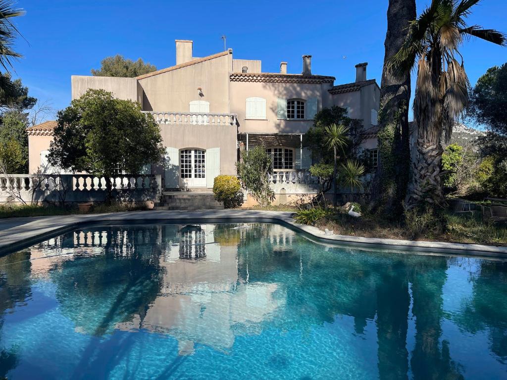 a large swimming pool in front of a house at Villa Grand Cèdre in Marseille