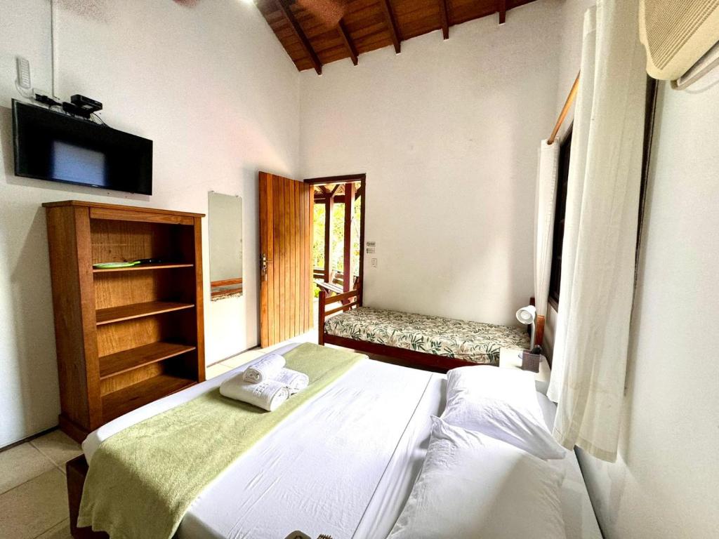 a bedroom with a bed and a television in it at Pousada do Riacho Trindade in Trindade