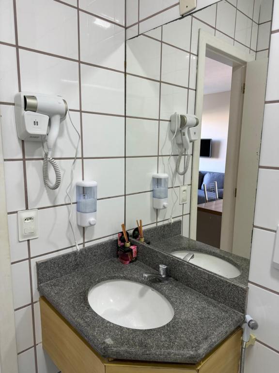 a bathroom with a sink and a mirror at Flat em frente à Praia in Vitória