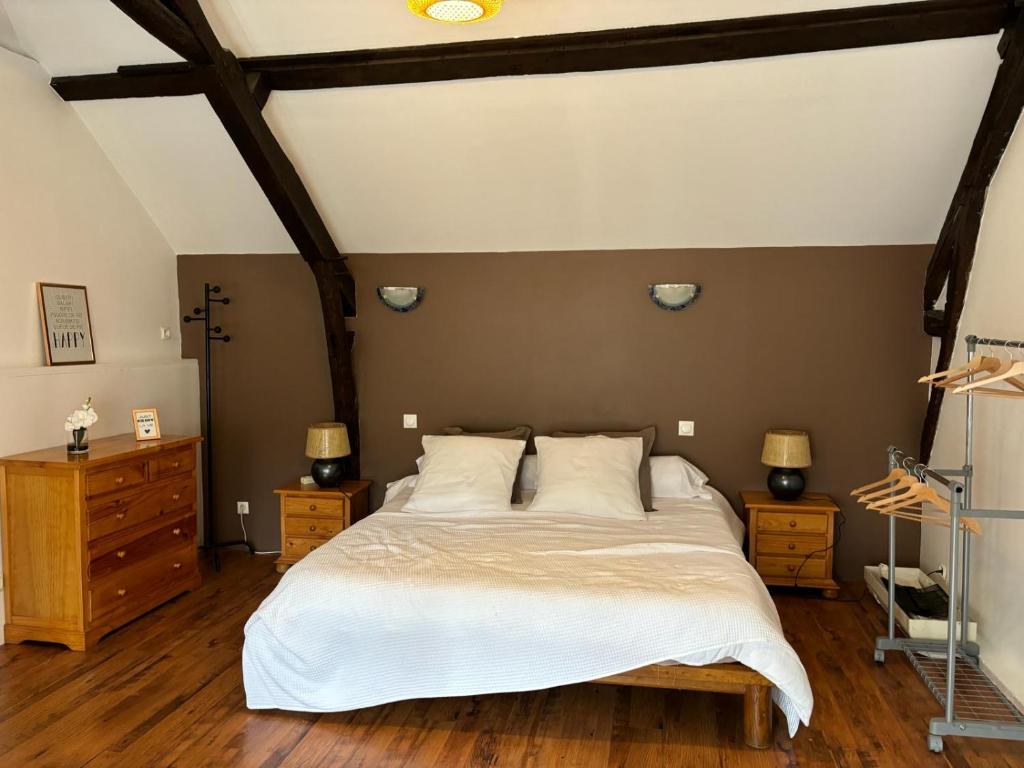 une chambre avec un grand lit et deux tables de nuit dans l'établissement Gîte dans ferme rénovée 4-5 personnes, à Aubarède