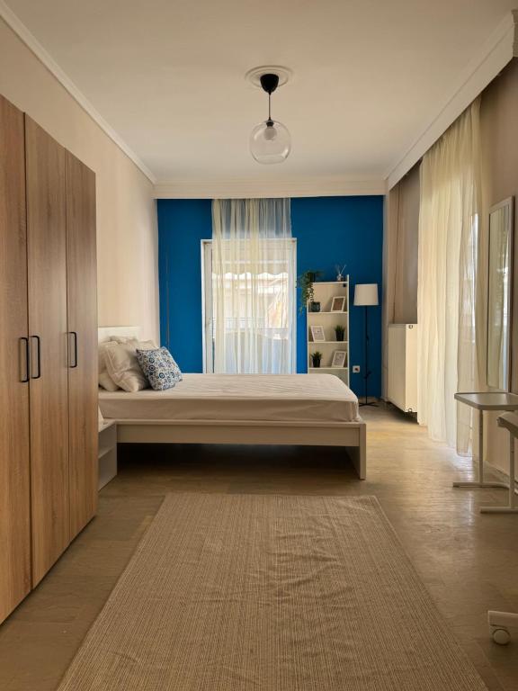 - une chambre avec un lit et un mur bleu dans l'établissement POSEIDON'S APARTMENT IN PERAIA - SUPERIOR BY THE SEA, à Peraia