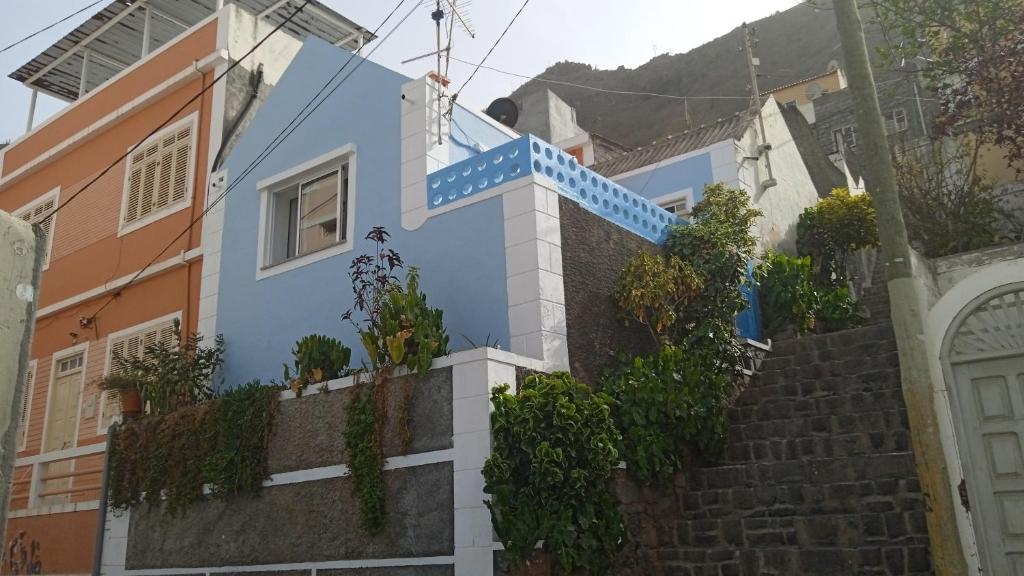 a blue house with stairs and plants on it at CasaMrichica in Ribeira Grande