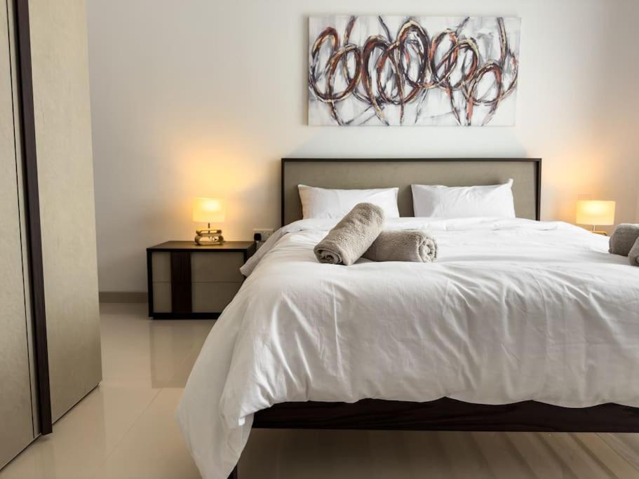 - une chambre avec un grand lit blanc et 2 oreillers dans l'établissement Hillcrest 3 Bedroom Apartment, à Mellieħa