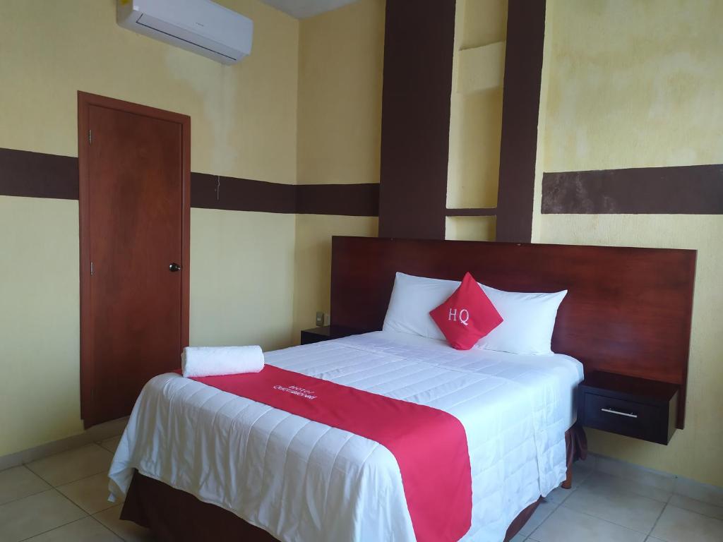 1 dormitorio con 1 cama grande con almohadas rojas en Hotel Quetzalcóatl, en Coatzacoalcos