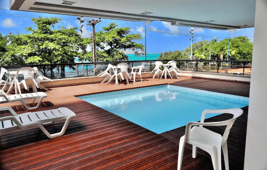 einen Pool auf einer Terrasse mit Stühlen und einem Tisch in der Unterkunft Villa Costeira Beira Mar - By Ideal Trip in Fortaleza