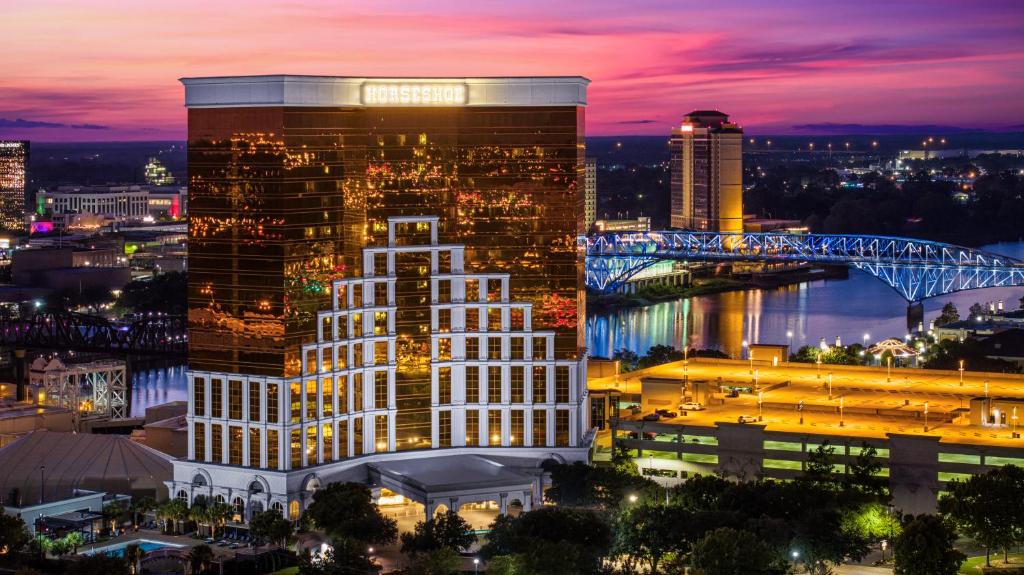 um edifício alto com um cartaz à noite em Horseshoe Bossier Casino & Hotel em Bossier City