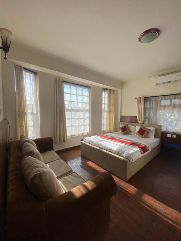 um quarto grande com uma cama e um sofá em grape apartments em Kathmandu