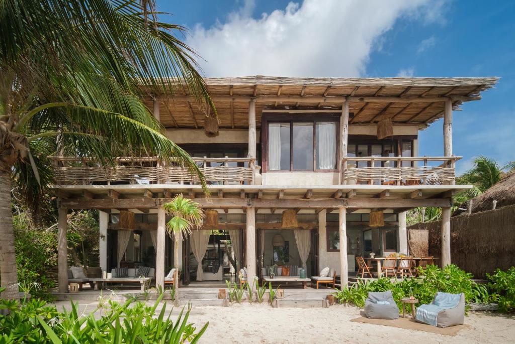 a house on the beach with a palm tree at Aldea Canzul Tulum in Tulum