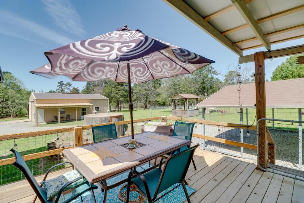 a patio table with an umbrella on a deck at Tumbling Shoals Home with Private Yard and Grill! in Heber Springs