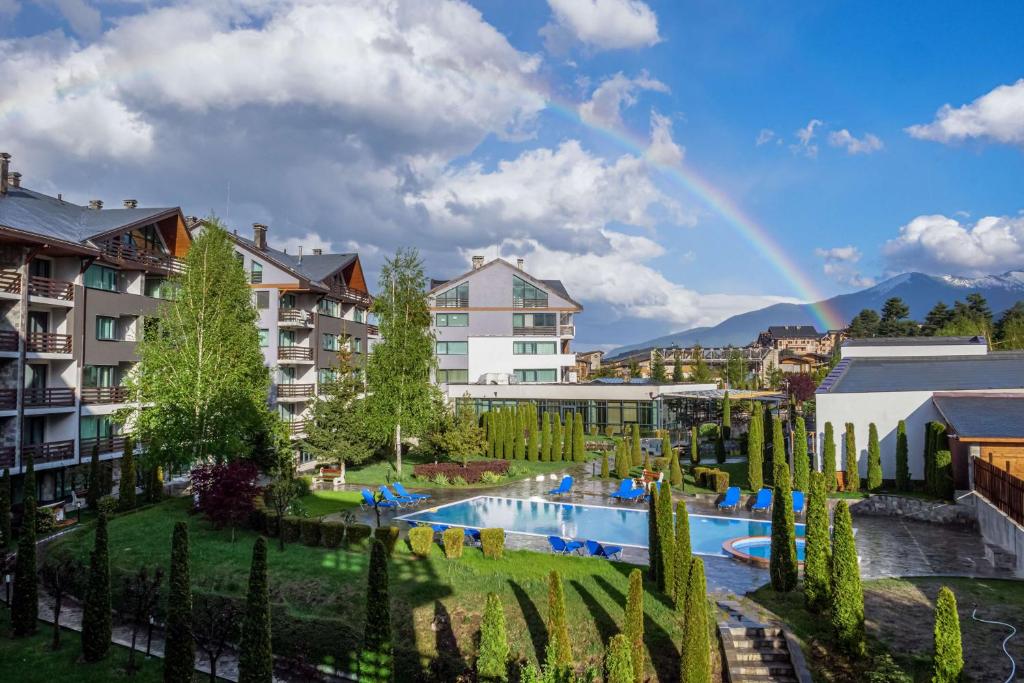 un arco iris sobre un complejo con piscina y árboles en Local Stay Hotel, BW Signature Collection, en Bansko
