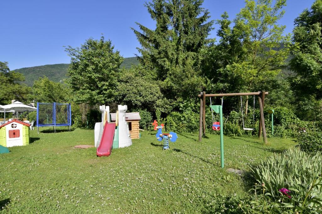 un patio con un parque infantil con un columpio en Hotel Bellavista, en Stenico