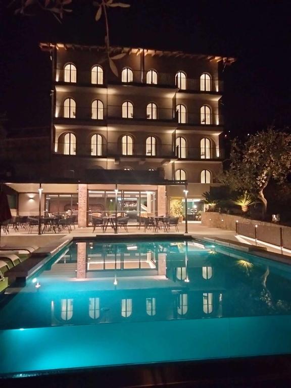 a hotel with a swimming pool in front of a building at Hotel Ristorante Al Caminetto WorldHotels Crafted Adults Only in Torri del Benaco