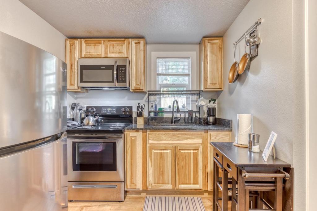 a kitchen with wooden cabinets and stainless steel appliances at Mt Air Unit 9 · Apt 9 at the base of Mt Hood in Mount Hood Village