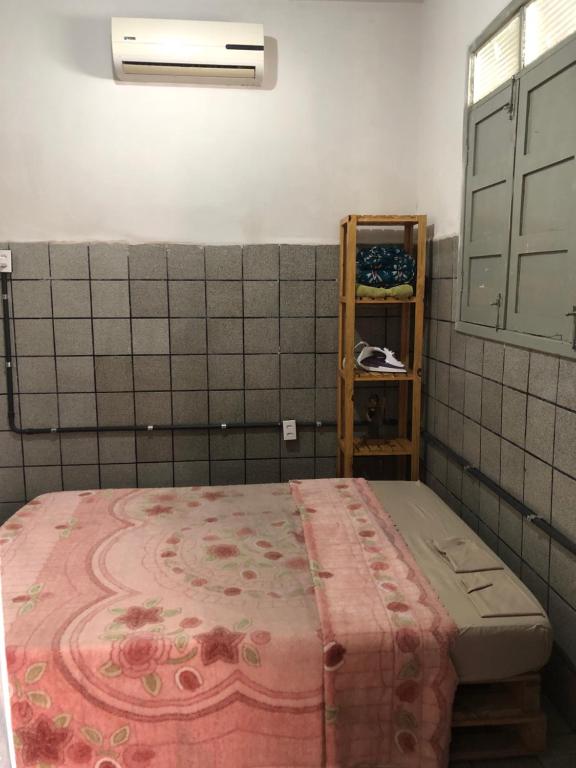 - une chambre avec un lit recouvert d'une couverture rose dans l'établissement Vegaspub1600, à Campina Grande