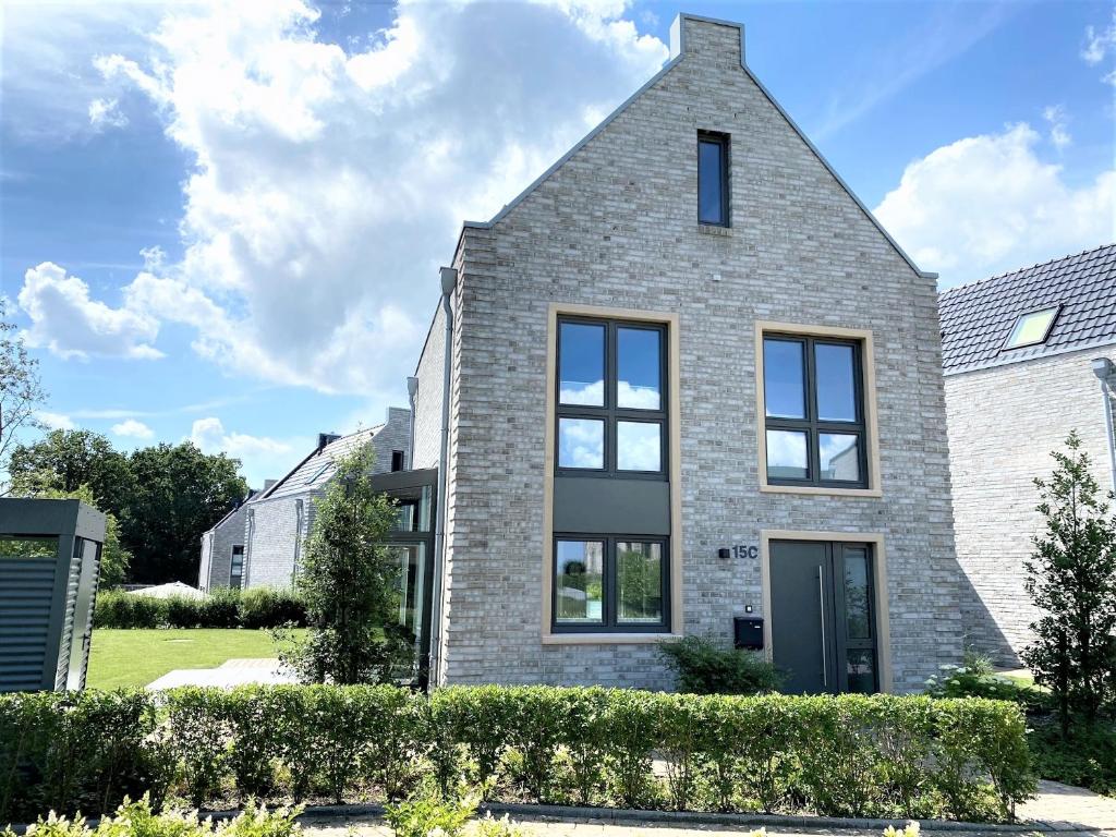 une maison en briques avec des fenêtres noires dans l'établissement Haus "Friesland 10", Am Alten Deich 15c, à Dangast