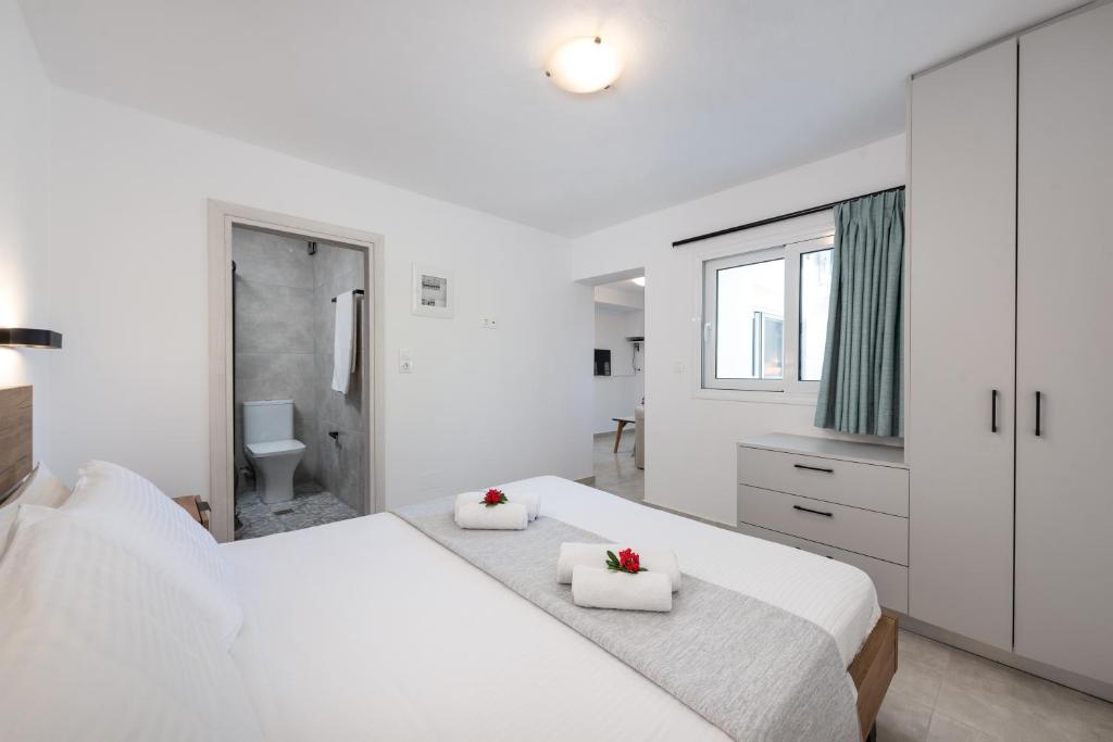 a white bedroom with two beds and a bathroom at GIAMARIN in Istro
