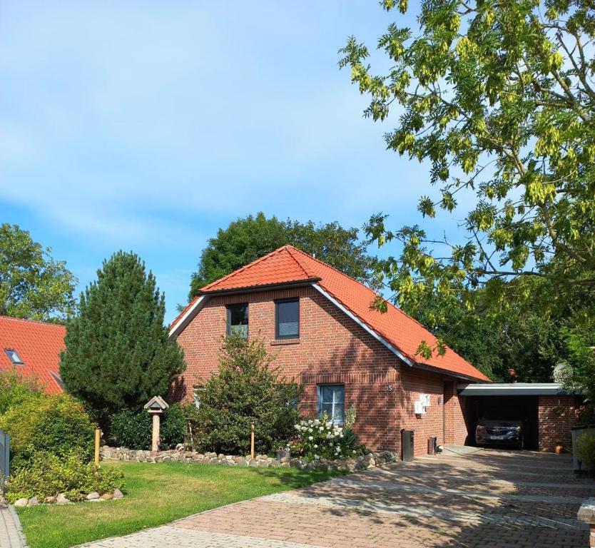 ein Backsteinhaus mit orangefarbenem Dach in der Unterkunft Apartment FriesenLück in Bockhorn