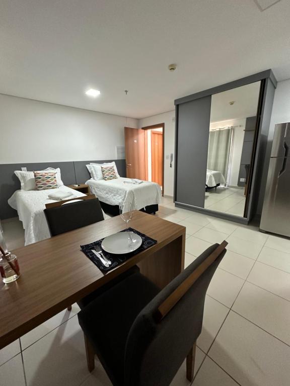 um quarto com uma mesa de jantar e um quarto com 2 camas em Studio 606 - Expetacular em Ribeirão Preto