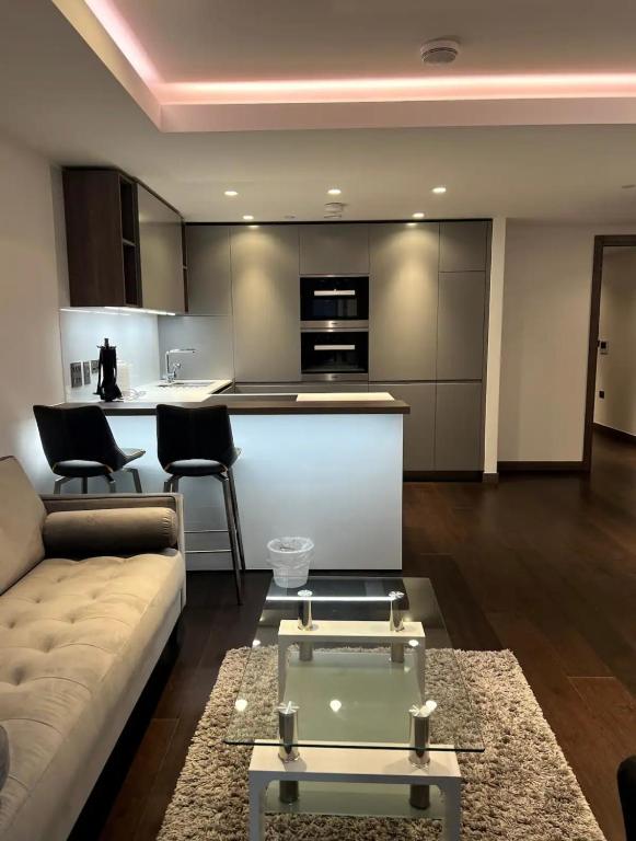 ein Wohnzimmer mit einem Sofa und einer Küche in der Unterkunft Luxury Flat In Paddington in London