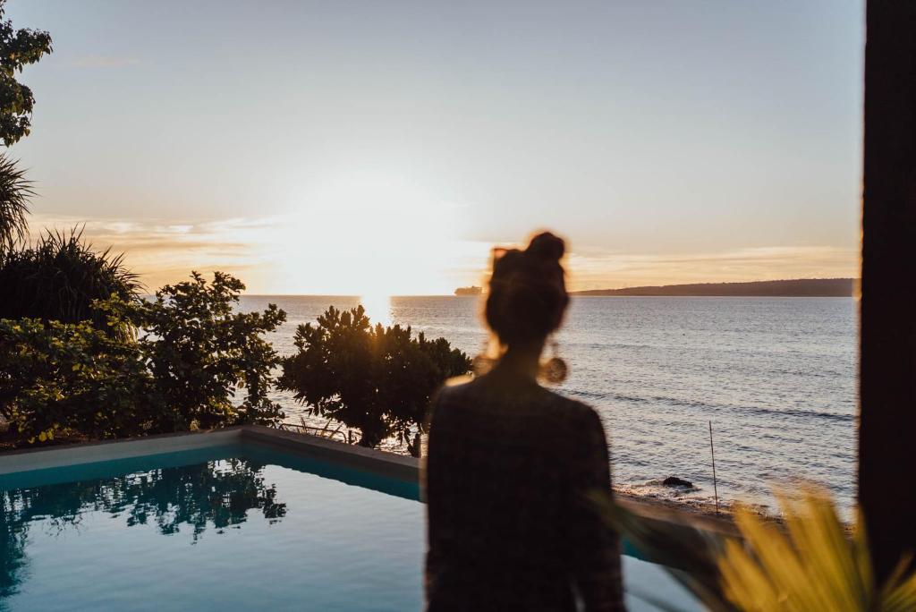 Una mujer mirando por una ventana al océano en South Pacific Memories, en Port Vila