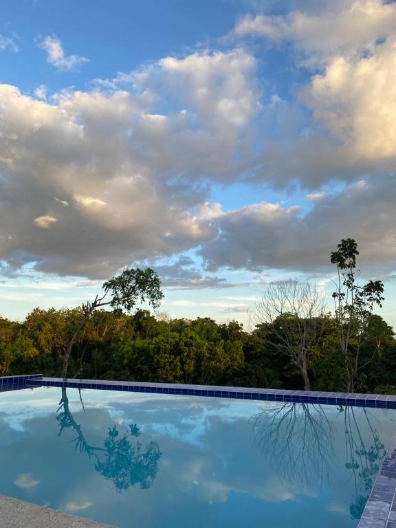 einem Pool mit wolkigem Himmel im Hintergrund in der Unterkunft Eco Park - Albur Rental Properties in Alburquerque