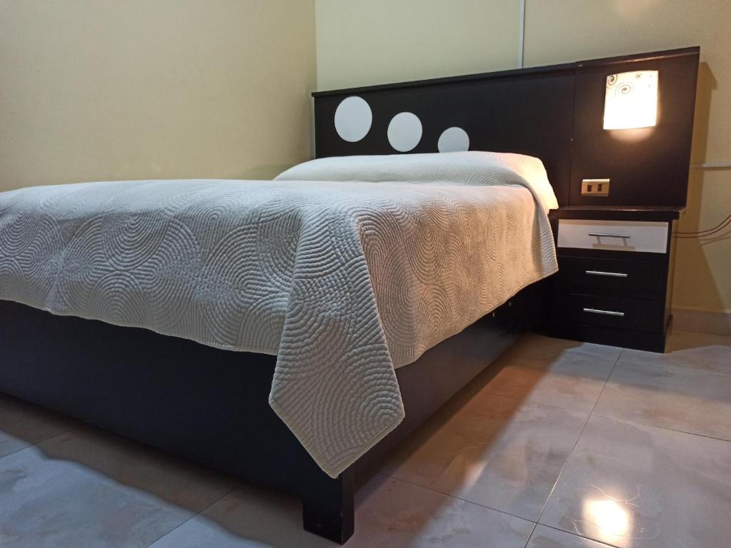 een slaapkamer met een groot bed en een witte deken bij Jurassic Hostal in Torotoro