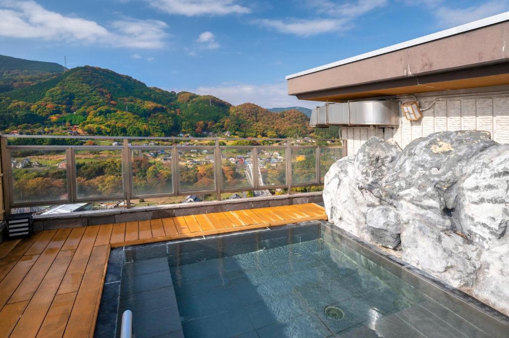 a swimming pool on top of a building with a mountain at KAMENOI HOTEL Nagatoro Yorii in Yorii