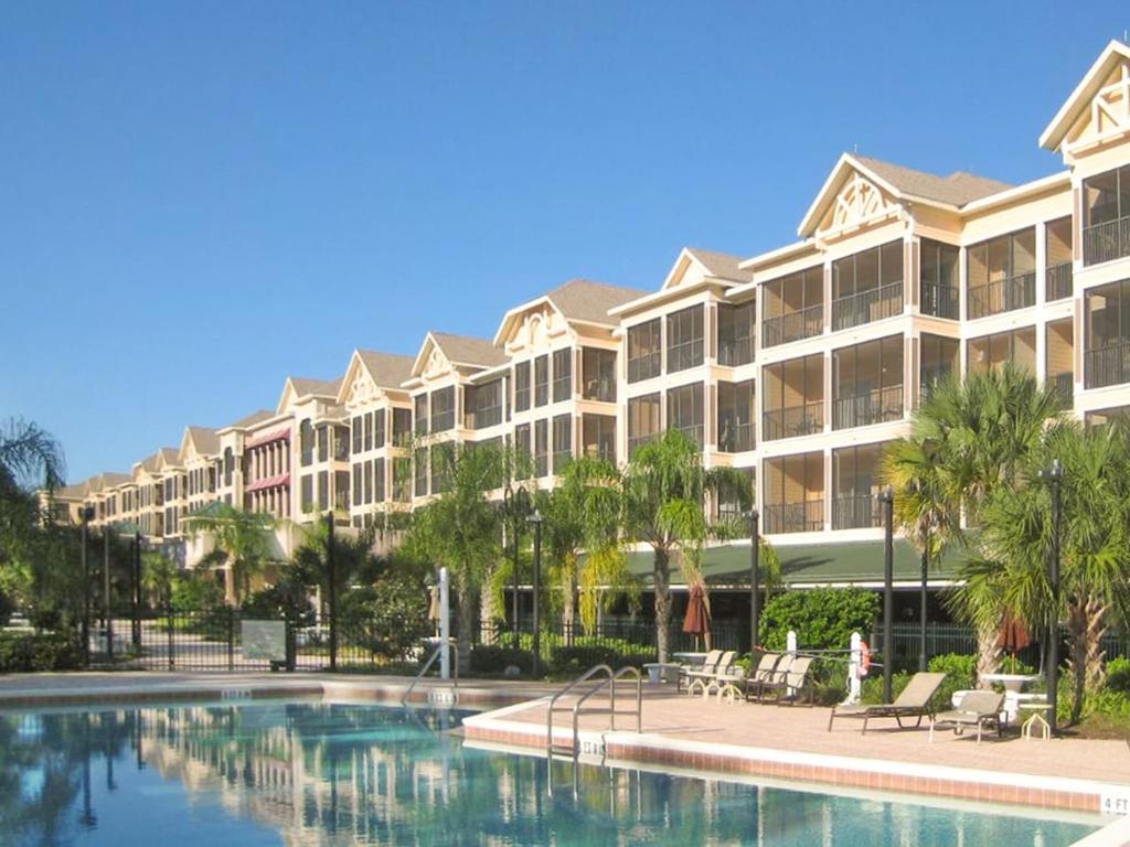 un complexe avec une piscine et des palmiers dans l'établissement Luxury 3BR Near Disney - Pool and Hot Tub!, à Orlando
