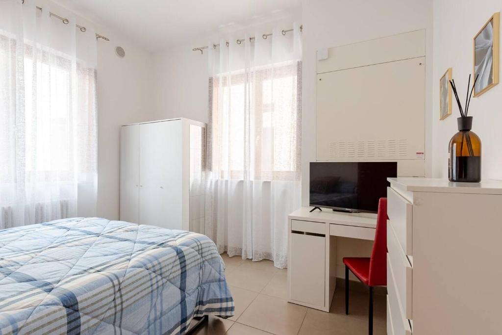 sypialnia z łóżkiem, biurkiem i telewizorem w obiekcie Dimora del Sole 2 - Intero Appartamento w mieście LʼAquila