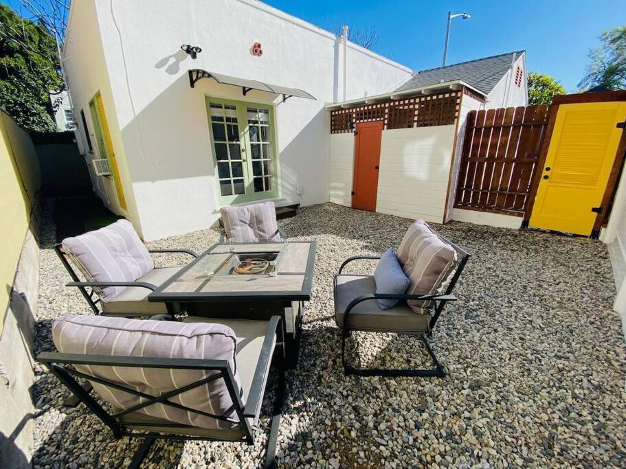 un patio avec une table et des chaises et un bâtiment dans l'établissement Chic 1,400 sq ft home in WeHo 2BR 2BA Gated, à Los Angeles