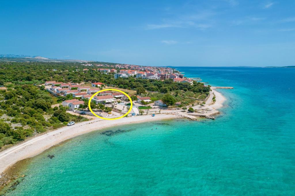 eine Luftansicht auf einen Strand mit einem gelben Kreis in der Unterkunft Seaside house for families with children Mandre, Pag - 22604 in Kolan