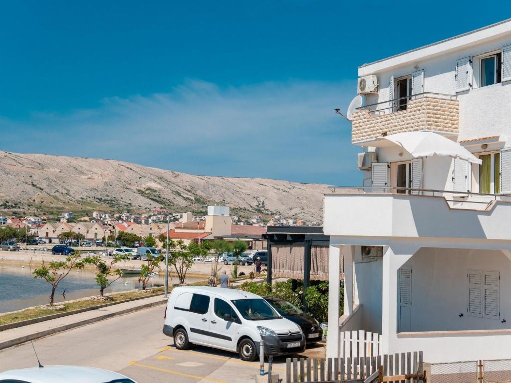 un furgone bianco parcheggiato in un parcheggio accanto a un edificio di Apartments with parking space Pag - 22605 a Pag