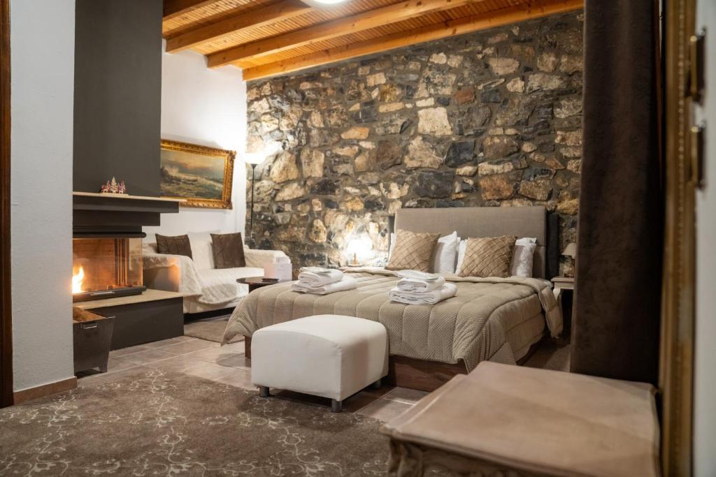 a bedroom with a bed and a stone wall at kaimak luxury chalet in Palaios Agios Athanasios