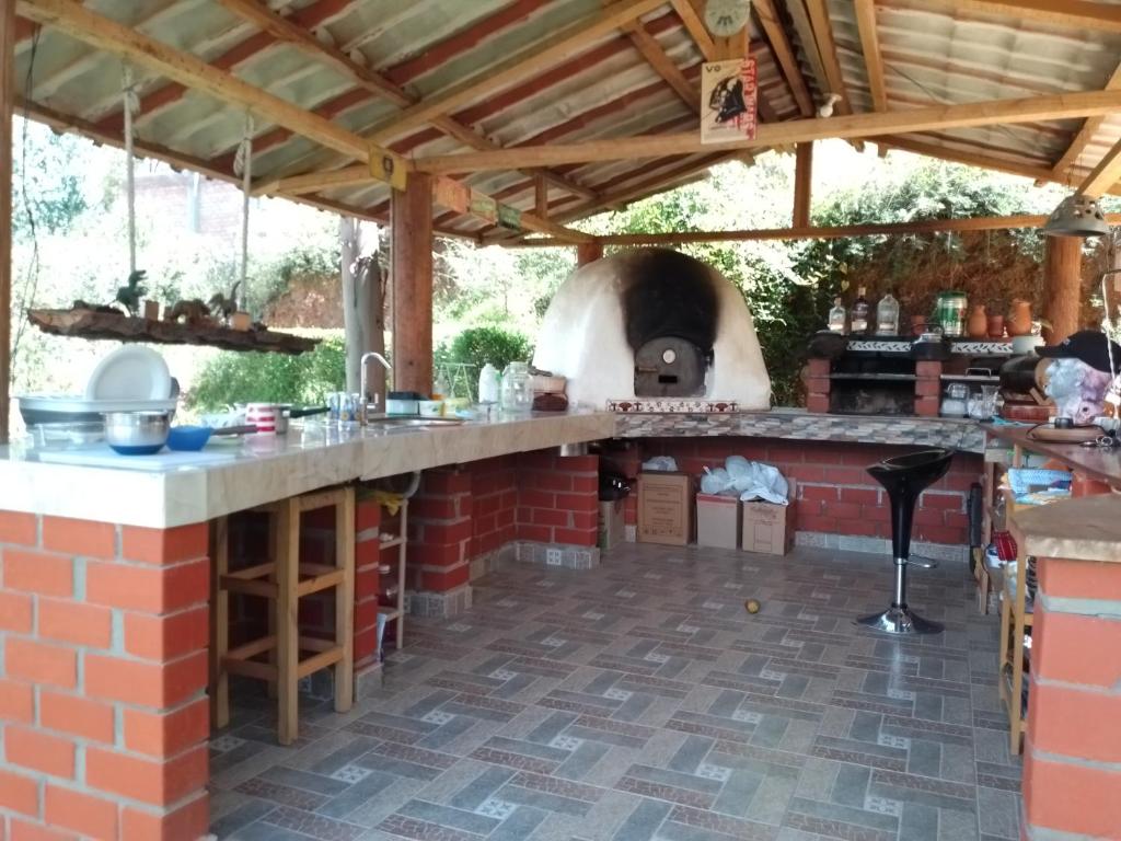 an outdoor kitchen with a pizza oven under a roof at Finca el pinar in Huaraz