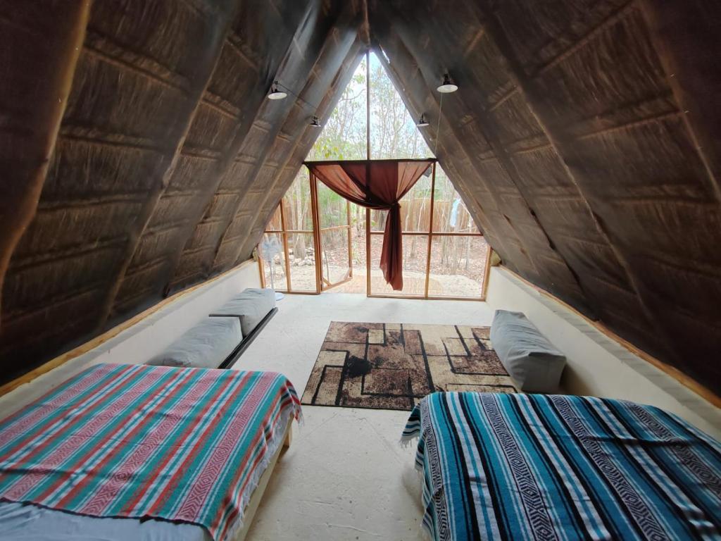 Zimmer mit 2 Betten und einem Fenster in der Unterkunft El Cenote 11:11 in Tulum