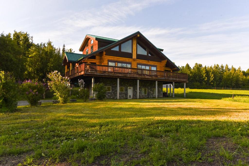 una casa de madera con un gran patio delante en Legacy Mountain Lodge on 40-Acre Ranch with Views!, en Palmer