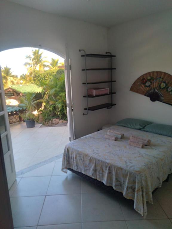 a bedroom with a bed and a door to a patio at Confortável, 1min da praia a pé in Niterói