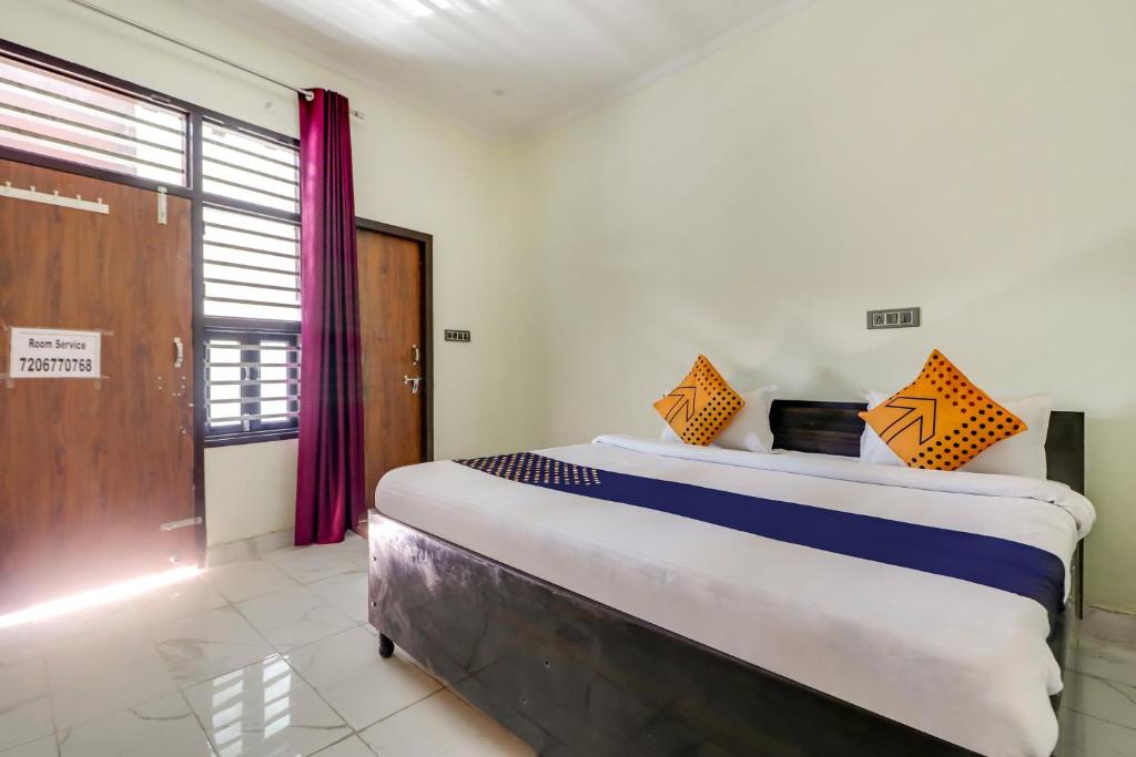 a large bed in a room with a large window at OYO 78256 Hotal Kesariya in Rewāri