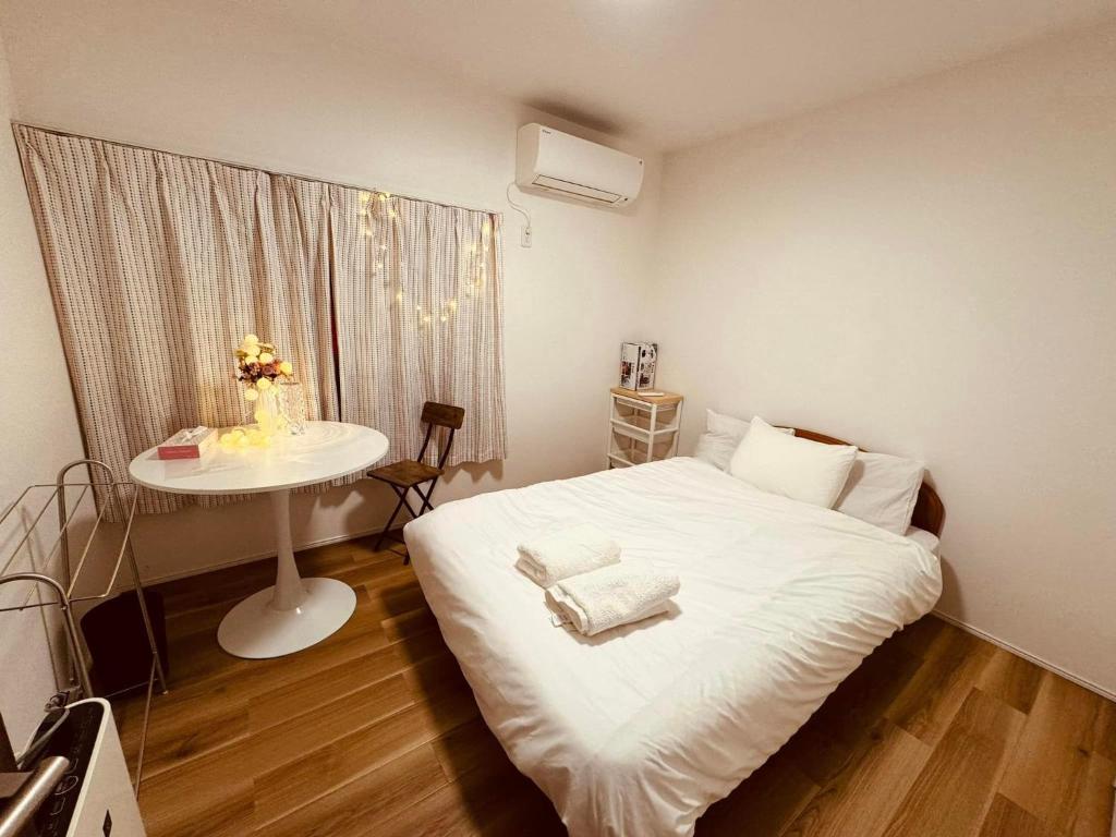 東京にあるNANA HOUSEの小さなベッドルーム(白いベッド1台、テーブル付)