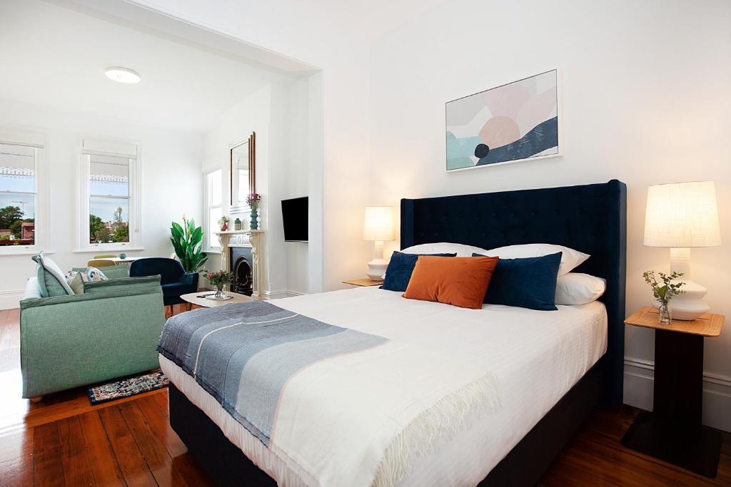 a bedroom with a large bed with blue and orange pillows at Spacious Studio With Balcony in Inner-City Glebe in Sydney
