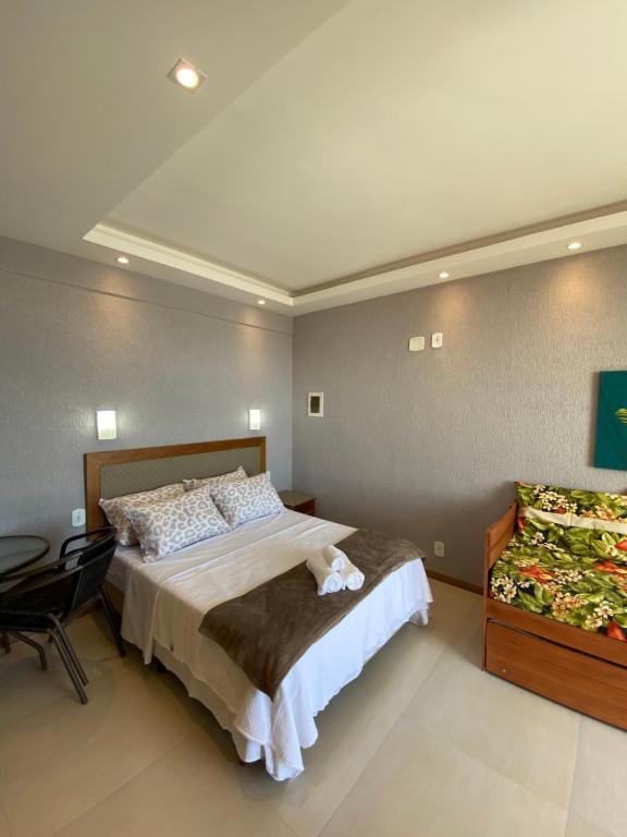 a bedroom with a bed and a table in it at Varandas ao mar loft 302 Praia Grande in Arraial do Cabo