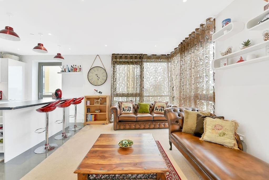 a living room with a couch and a table at Spacious, Stylish & Secure Apartment in London