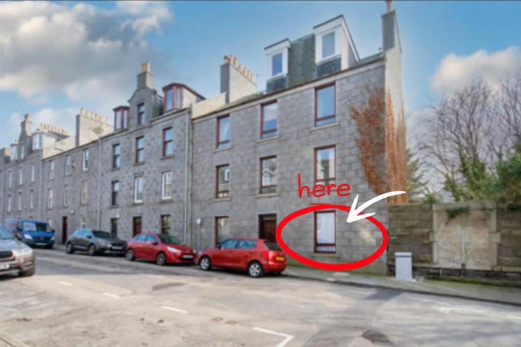 a building with a sign that says here next to parked cars at 21 Stafford Street (GFR) in Aberdeen