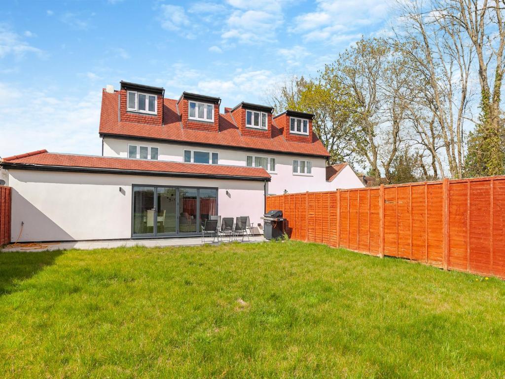 ein großes weißes Haus mit einem orangenen Zaun in der Unterkunft Uk46877 - 1 Orchard Farm Cottage in East Grinstead